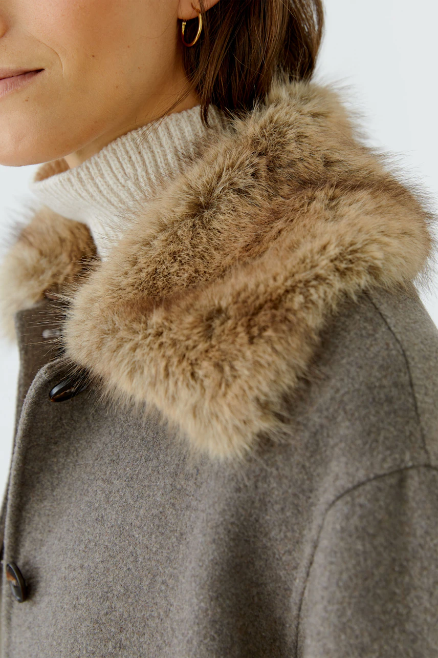 Damen-Jacke: Frau in grauer Jacke mit Fellkragen und hellem Rollkragenpullover.