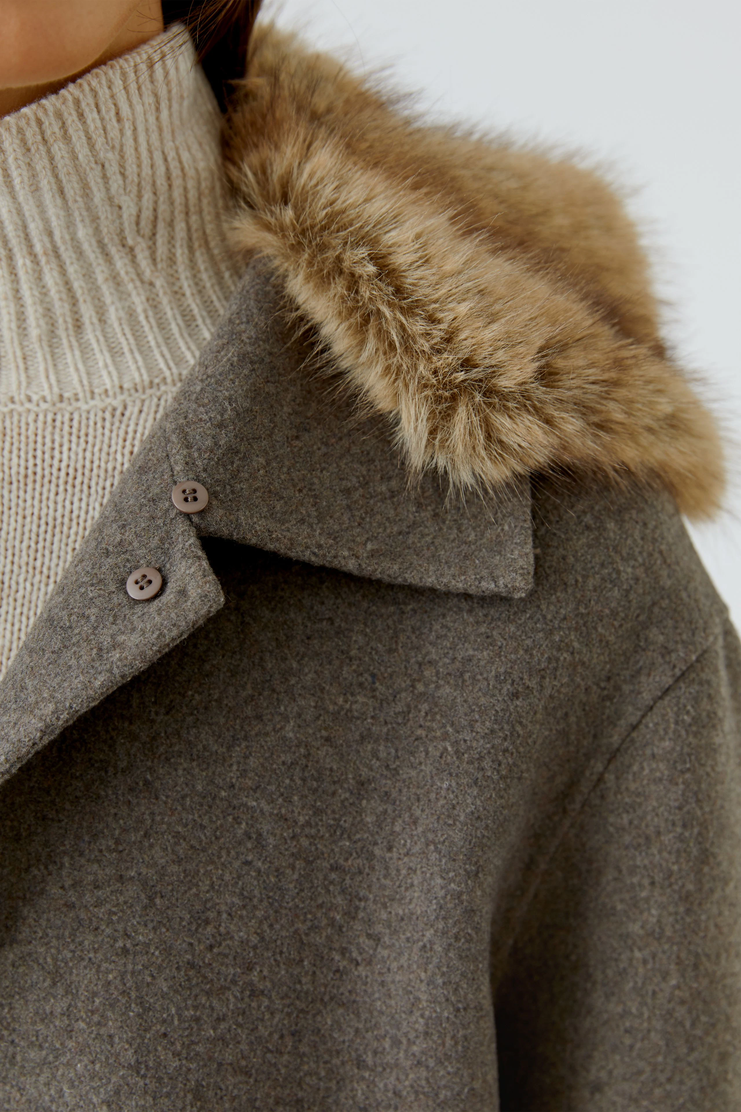 Damen-Jacke: Frau in grauer Jacke mit Fellkragen und beigem Rollkragenpullover.