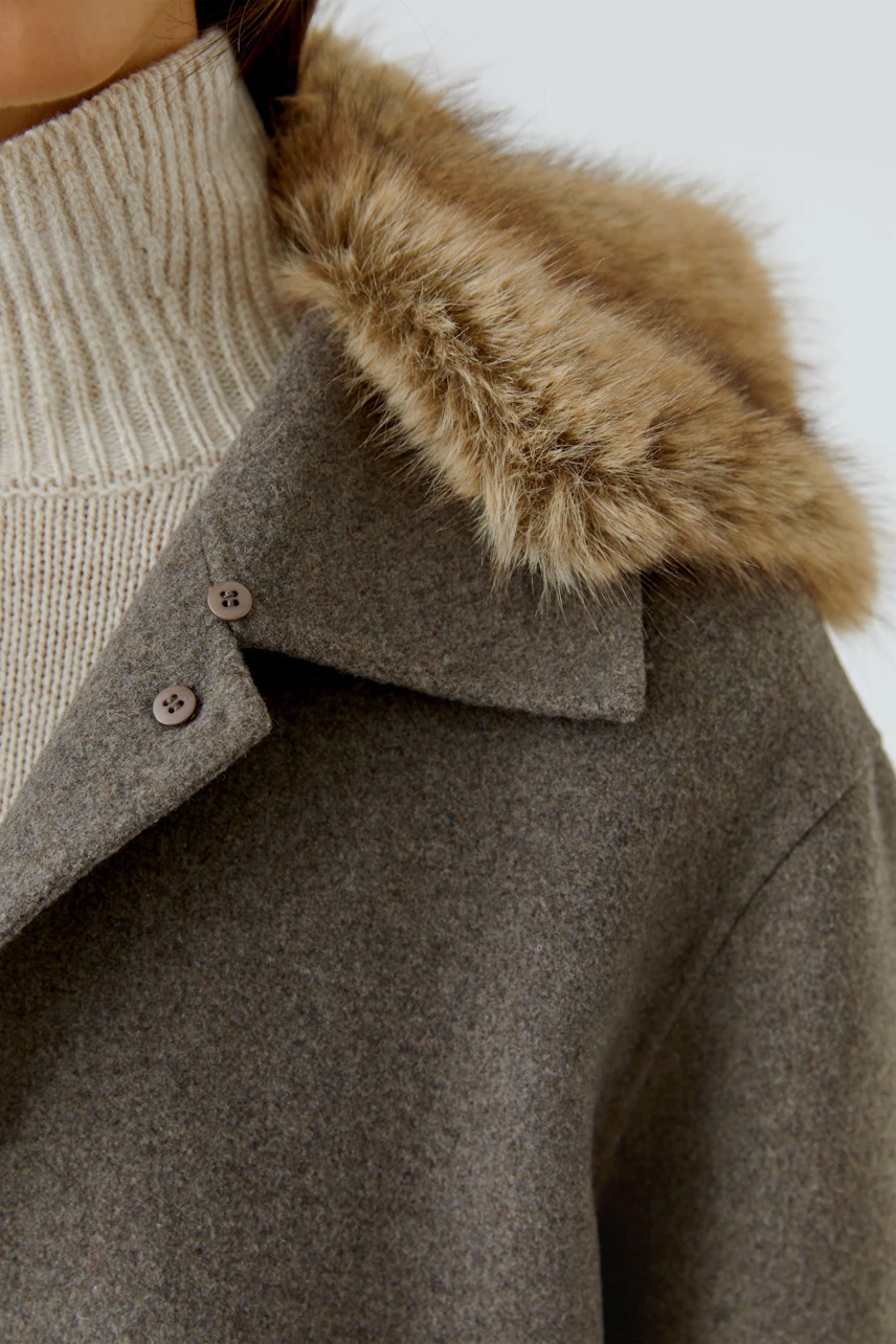 Damen-Jacke: Frau in grauer Jacke mit Fellkragen und beigem Rollkragenpullover.