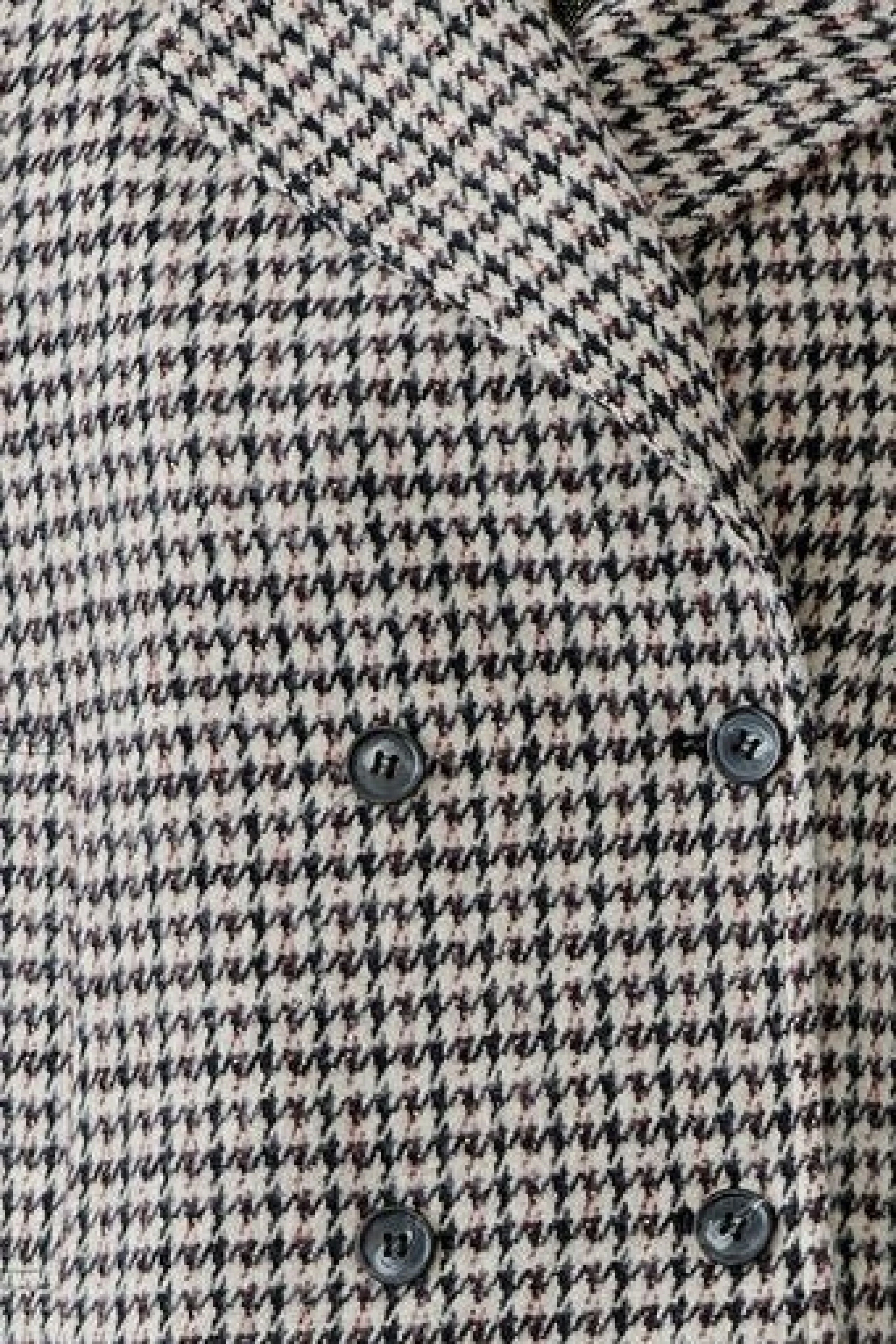 Kariertes Damen-Jacke: Nahaufnahme eines klassischen Hahnentritt-Musters mit Knöpfen.