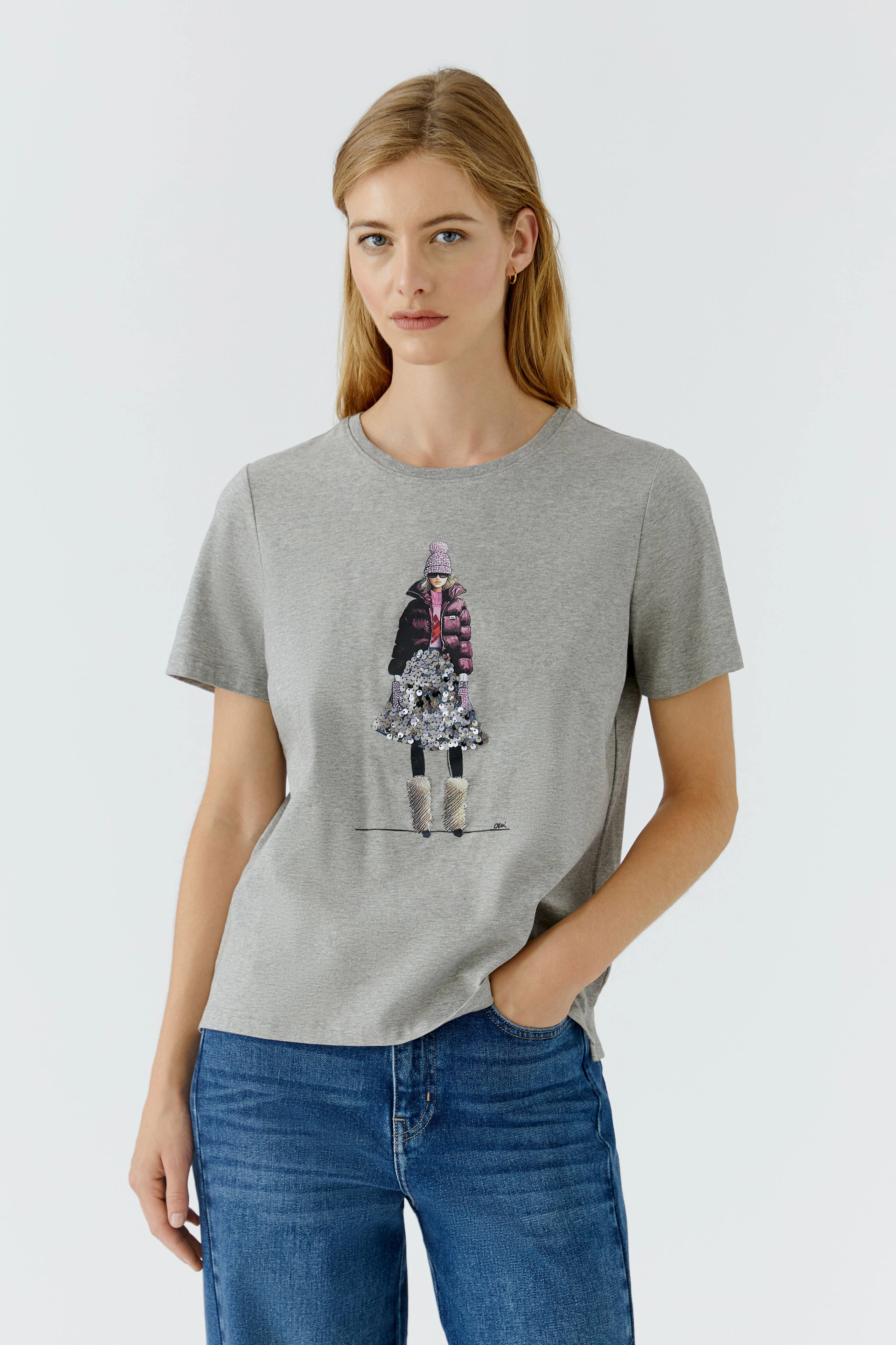Casual women's T-shirt: Woman in a gray T-shirt with a graphic print, paired with blue jeans.