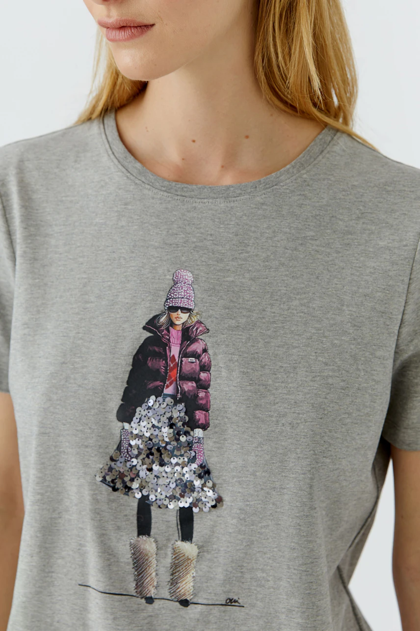 Casual women's T-shirt: Woman in a grey T-shirt with a stylish graphic print of a winter outfit.