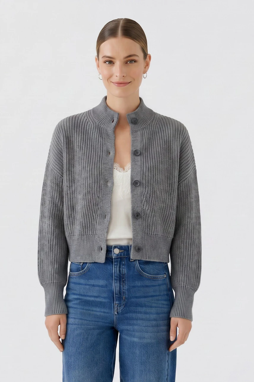 Graue Strickjacke: Frau trägt eine graue Strickjacke über einem weißen Top und blauen Jeans.