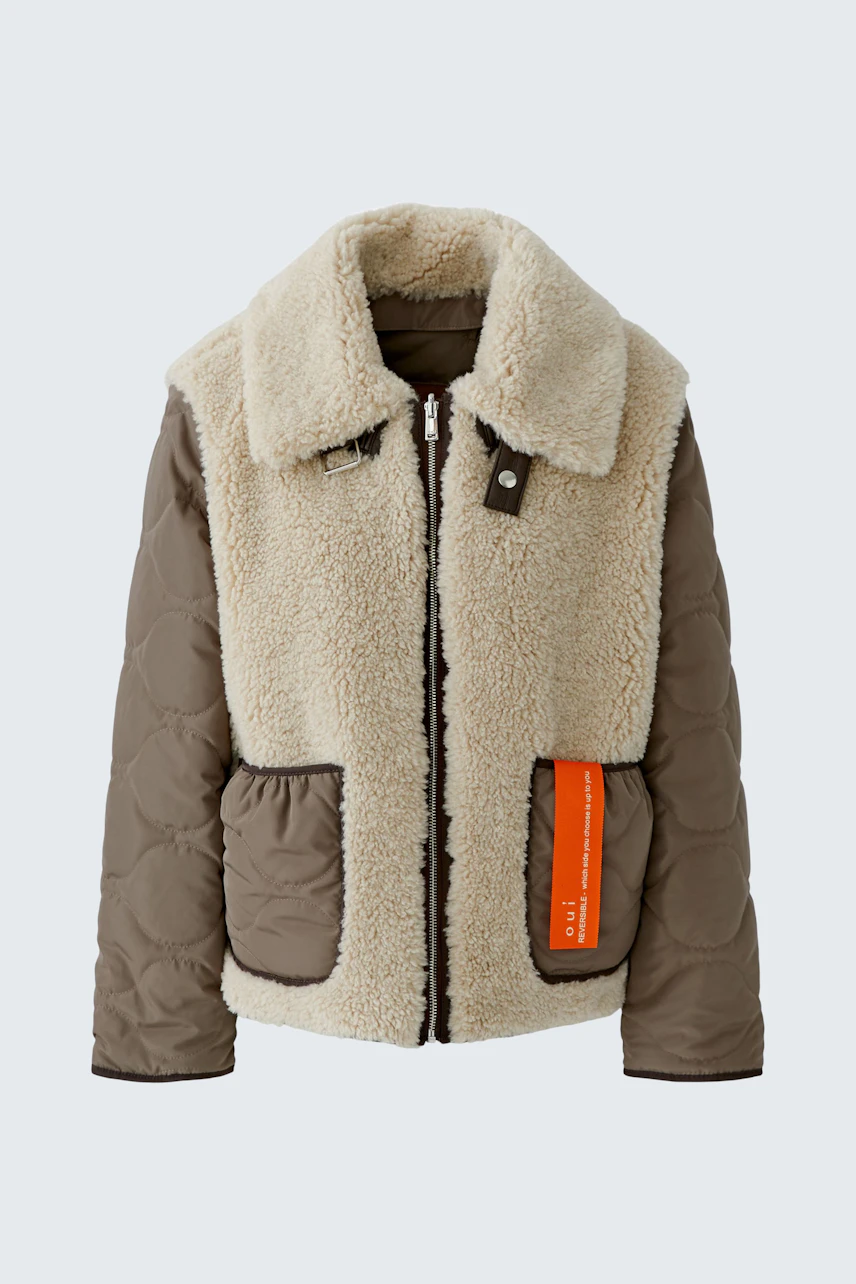 Cozy outdoor jacket: Brown quilted sleeves, fluffy beige body, and orange pocket detail. No model shown.