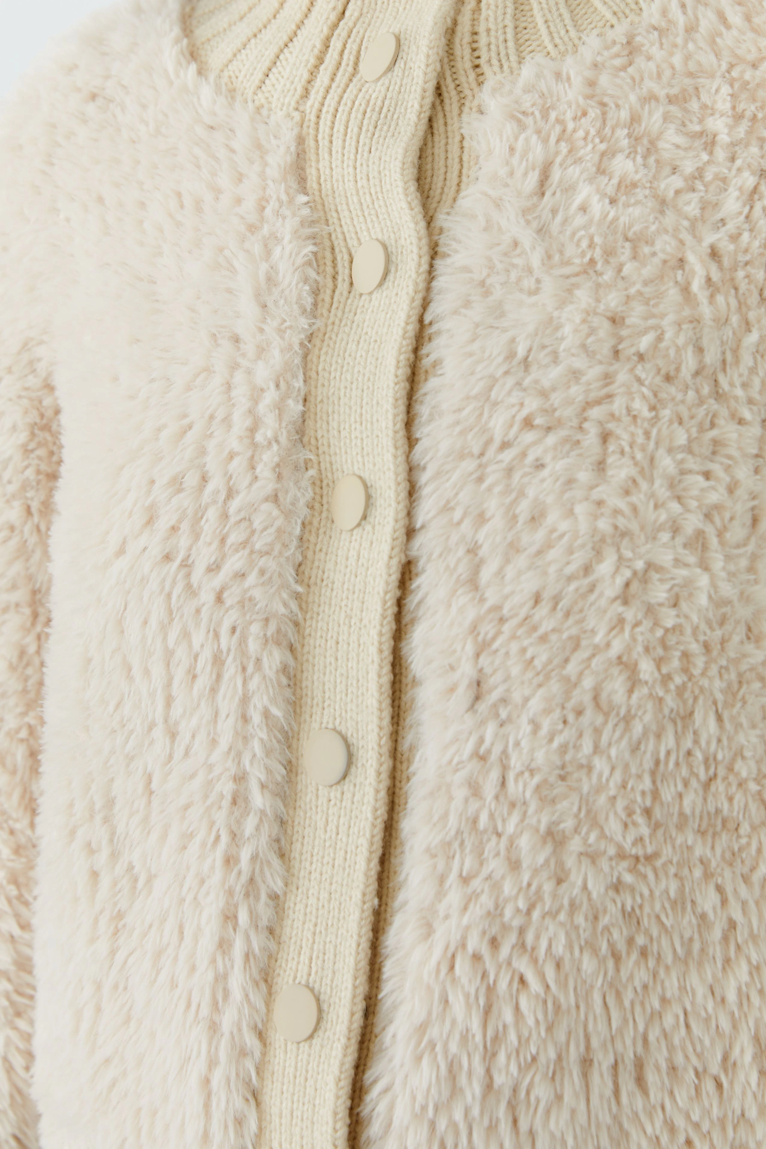 Kuschelige Strickjacke in Creme mit Knopfleiste, ideal für gemütliche Tage.