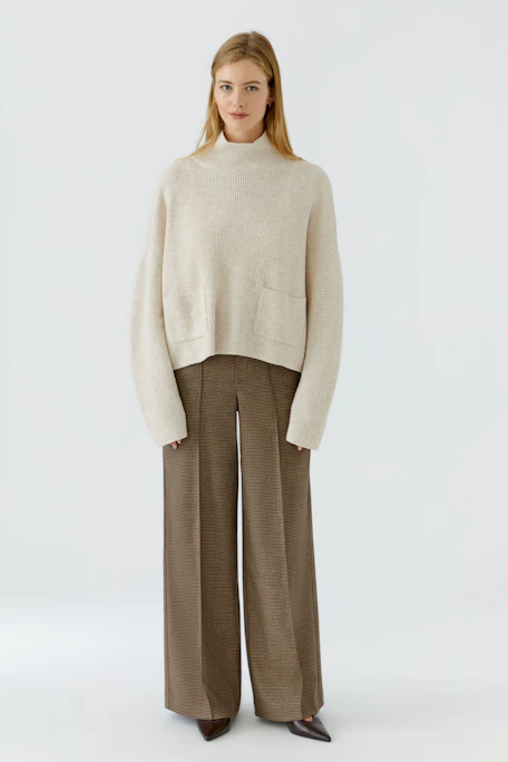 Beiger Damen-Pullover: Lockerer Strickpullover mit hohem Kragen und aufgesetzten Taschen, ohne Model.
