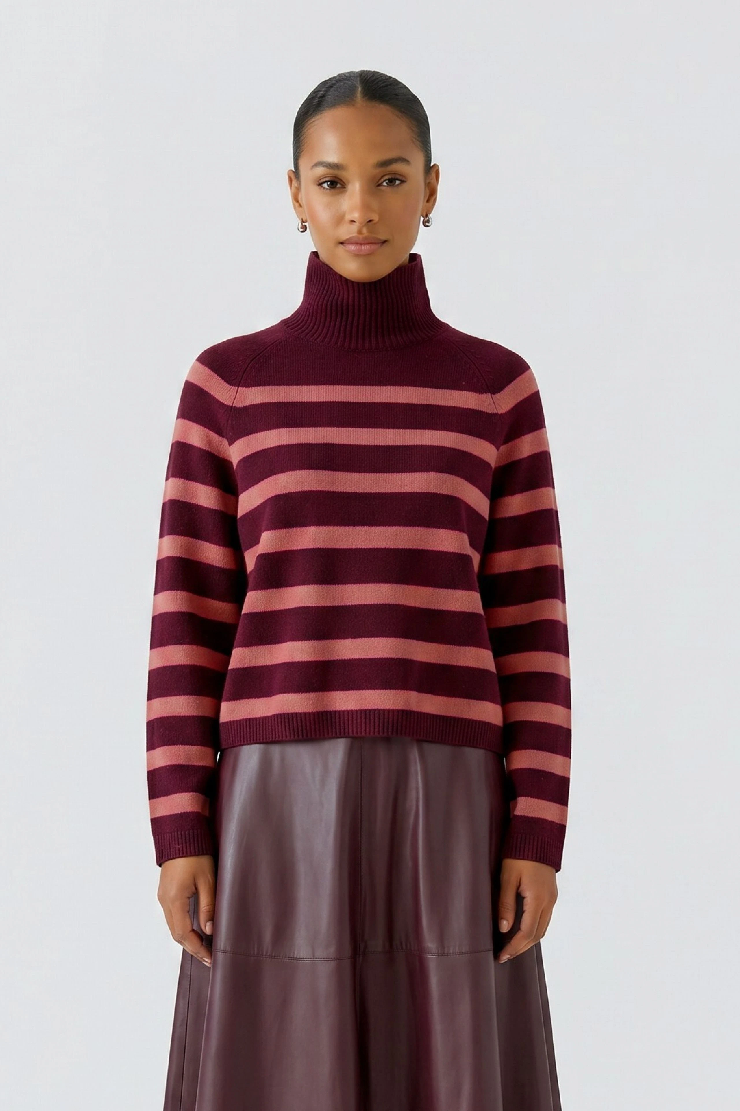 Gestreifter Damen-Pullover: Frau im rot-pink gestreiften Pullover mit Rollkragen und Lederrock.