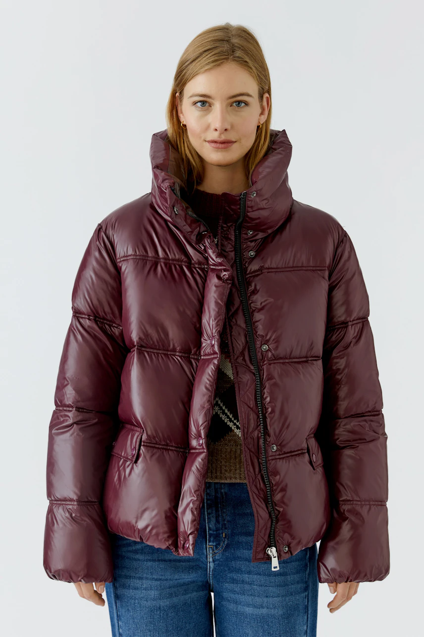 Frau in bordeauxfarbener Outdoorjacke: Steppjacke mit hohem Kragen, ideal für kalte Tage.
