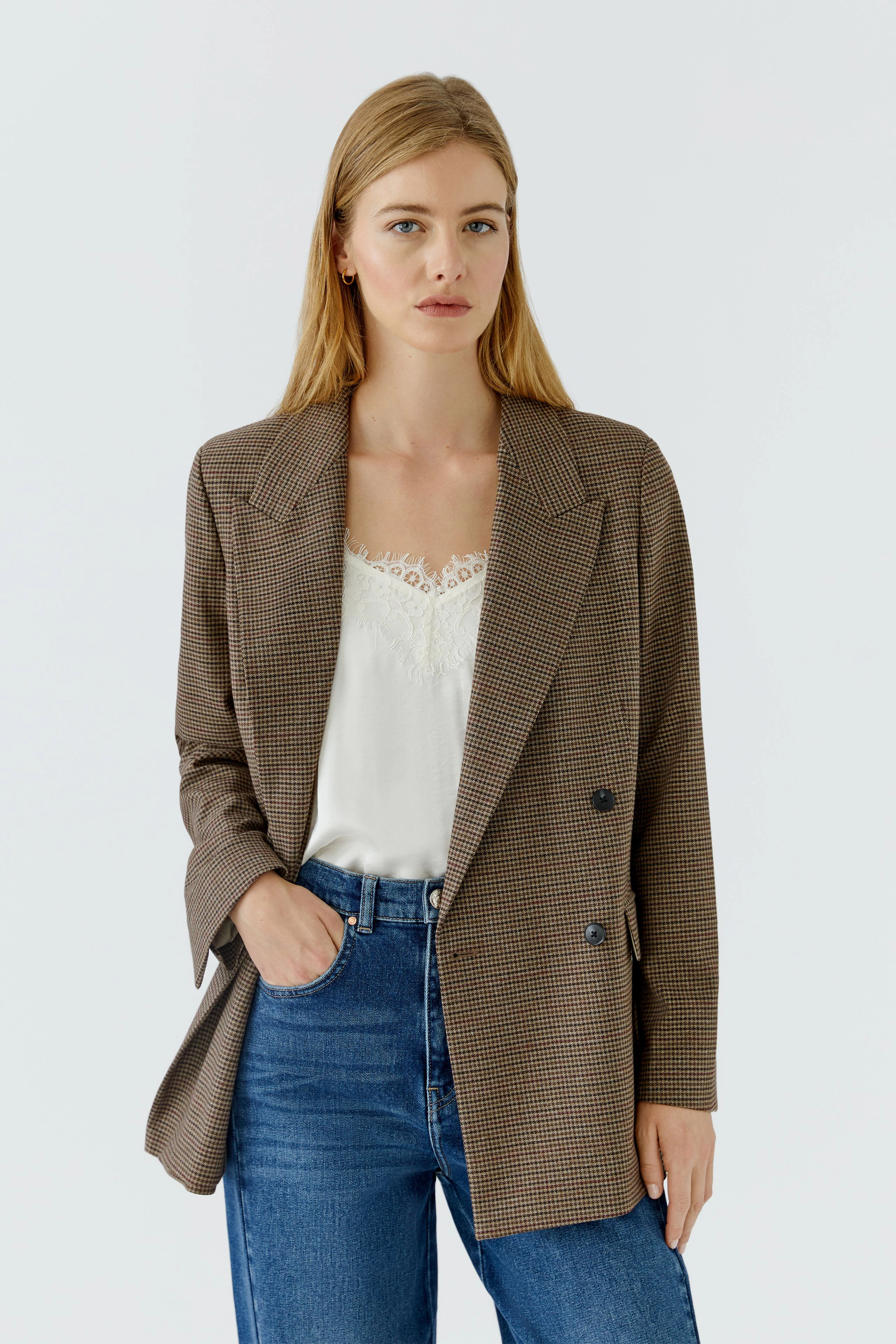 Lässiger Damen-Blazer: Frau im karierten Blazer mit weißem Top und Jeans, lässig und modern.