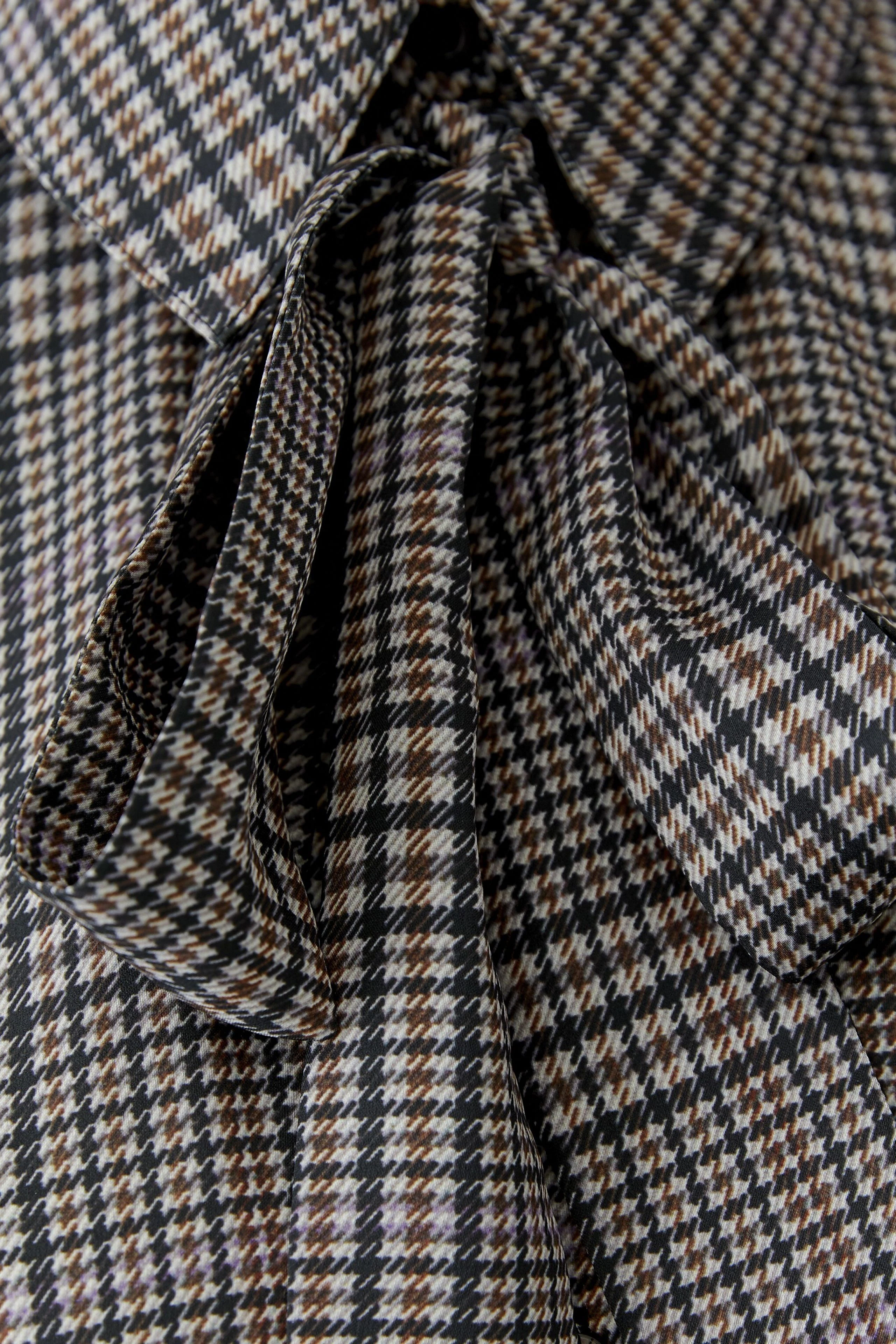 Schluppenbluse mit Karomuster: Detailansicht des Stoffes mit Schleife, ohne Model.