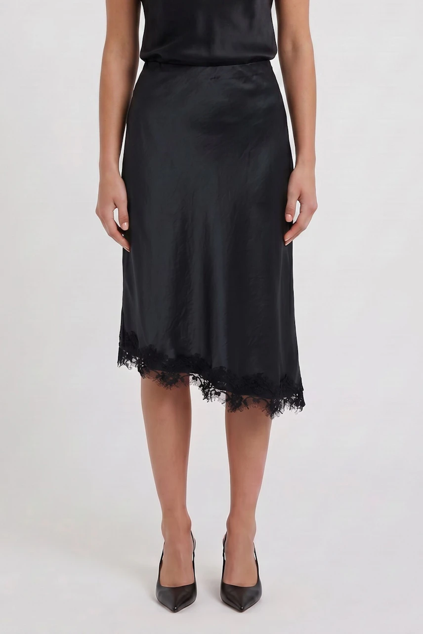 Woman in black pencil skirt with lace hem, paired with matching top and heels.