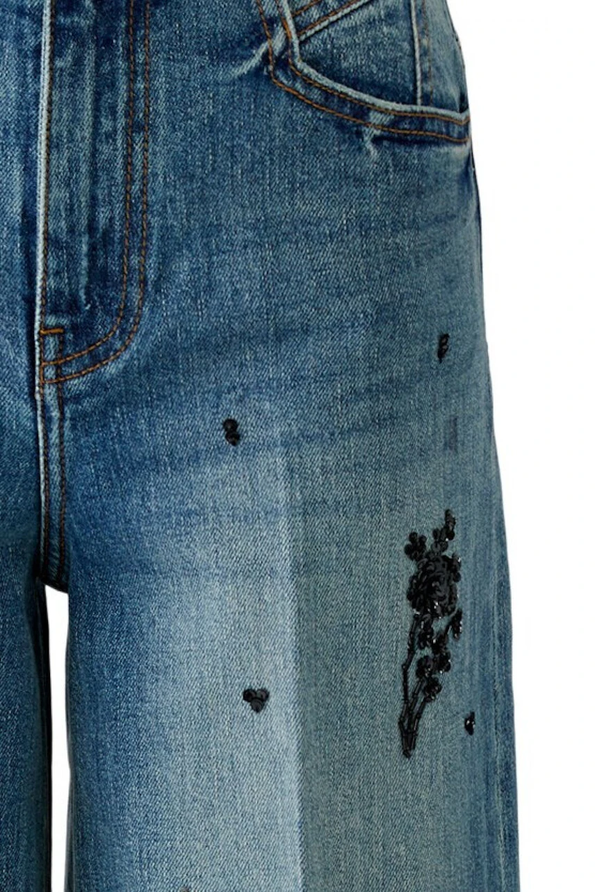 Jeans Wide Leg: Detailaufnahme einer blauen Jeans mit Stickerei, ohne Model.