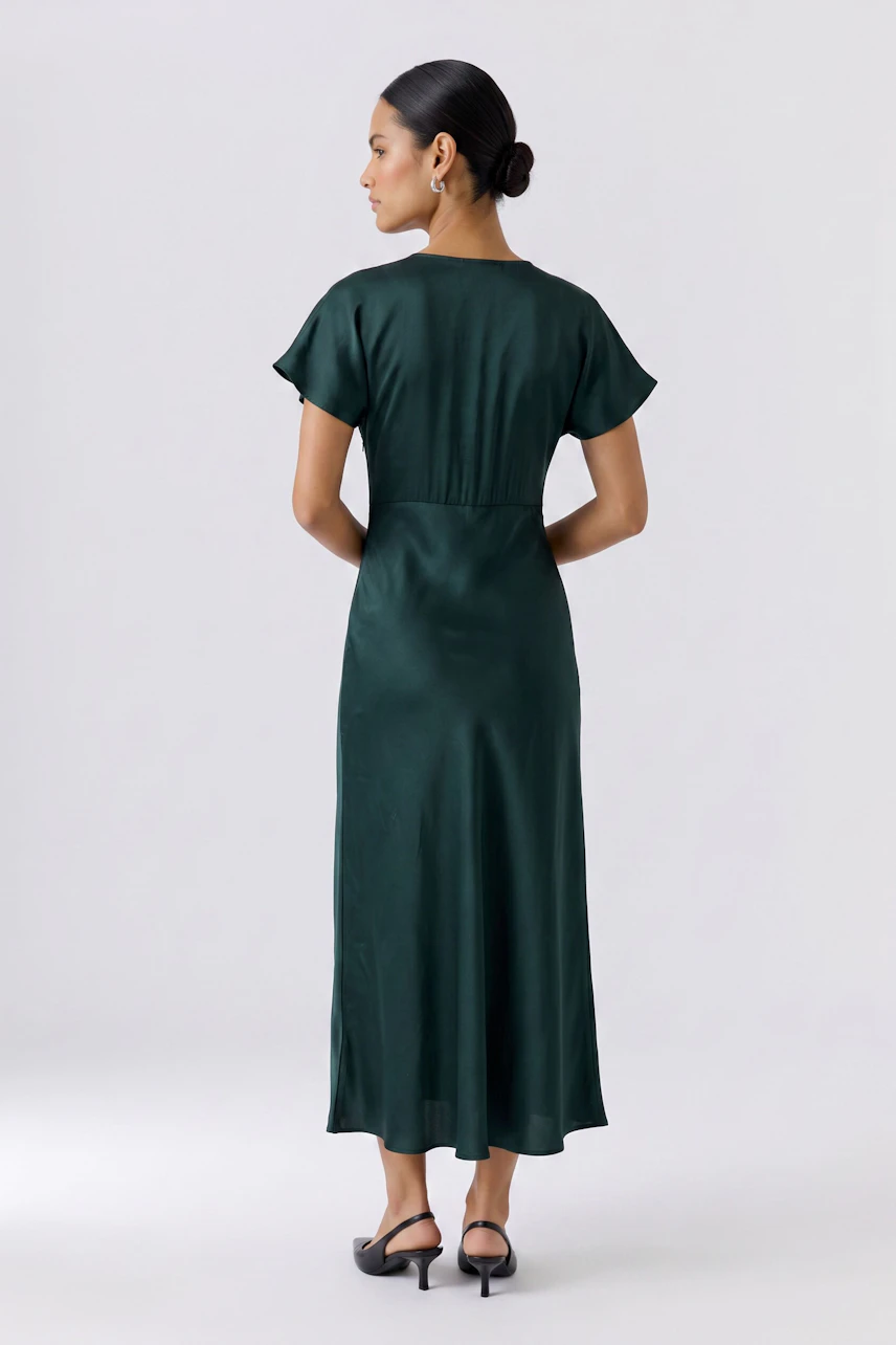 Woman in a green dress: Long, flowing dress with short sleeves, worn by a woman with a sleek hairstyle.