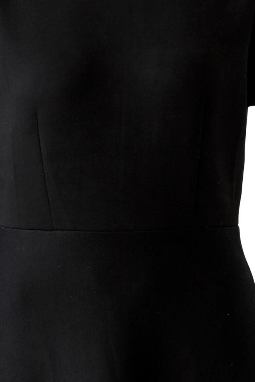 Simple black dress: Close-up of fabric texture, showcasing minimalist design and smooth finish.