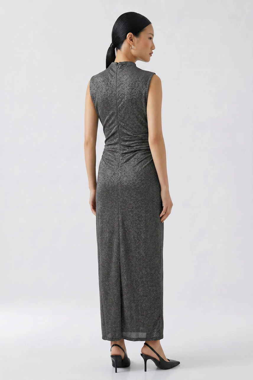 Casual dress: Woman in a long, sleeveless gray dress with a subtle pattern, standing confidently.
