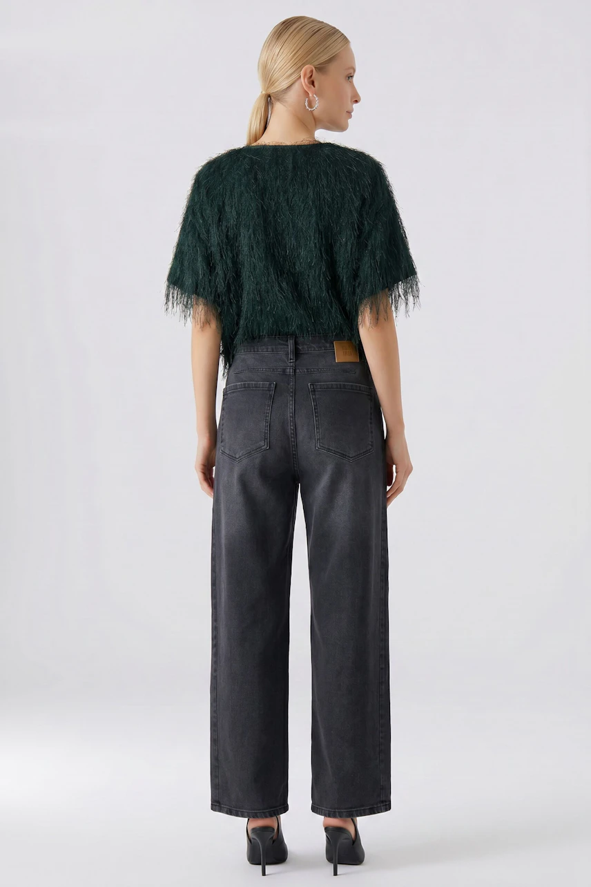 Casual T-shirt: Woman in a textured green T-shirt and black jeans, viewed from the back.