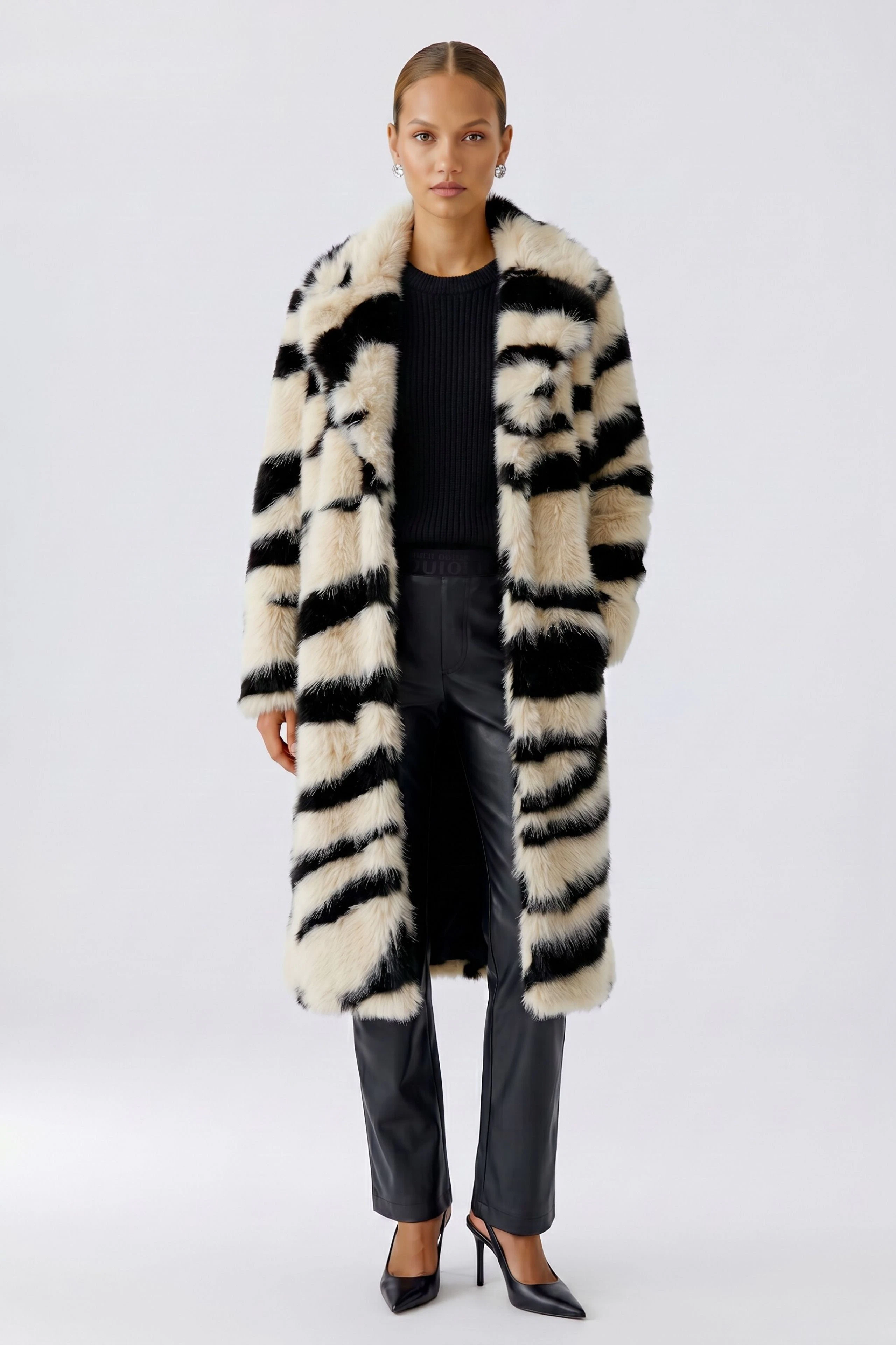 Stylischer Wintermantel: Langer Mantel mit auffälligem Streifenmuster in Schwarz und Beige, ohne Model.