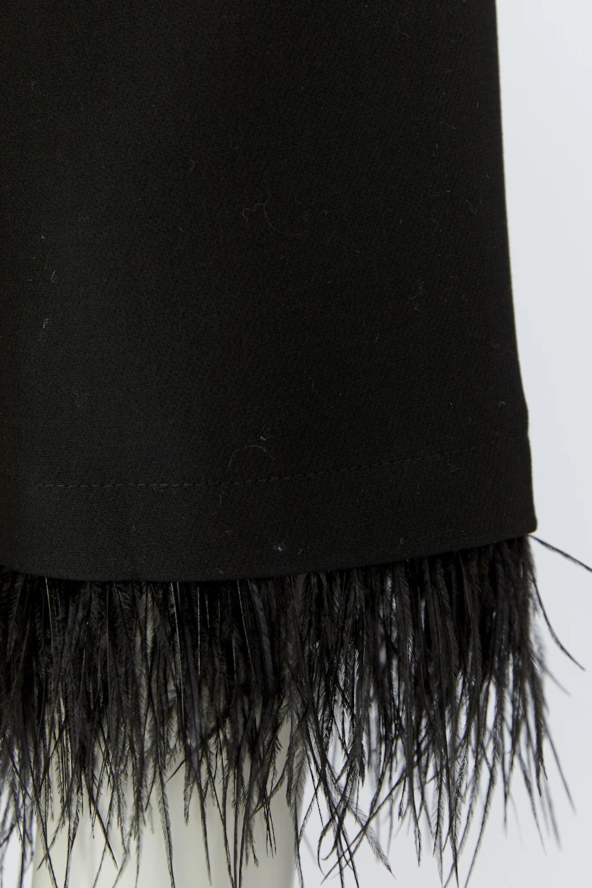 Schwarze Damen-Jacke mit Fransen: Detailansicht des Saums, keine Frau abgebildet.