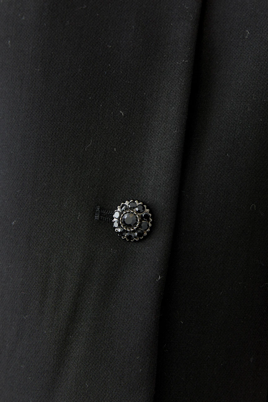 Schwarze Damen-Jacke mit dekorativem Knopfdetail, schlicht und vielseitig kombinierbar.