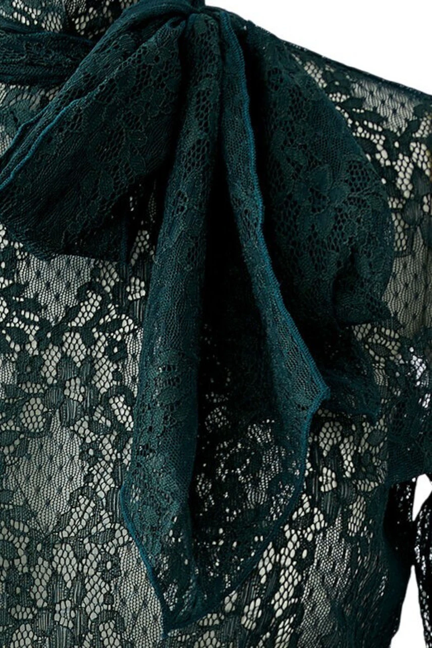 Women's long-sleeve shirt: Close-up of lace fabric with a bow detail, showcasing intricate design.