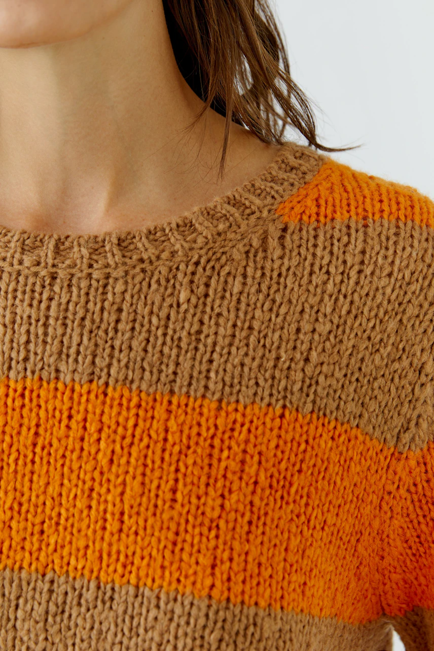 Frau im gestreiften Pullover: Grobstrick in Braun und Orange, lässiger Look.