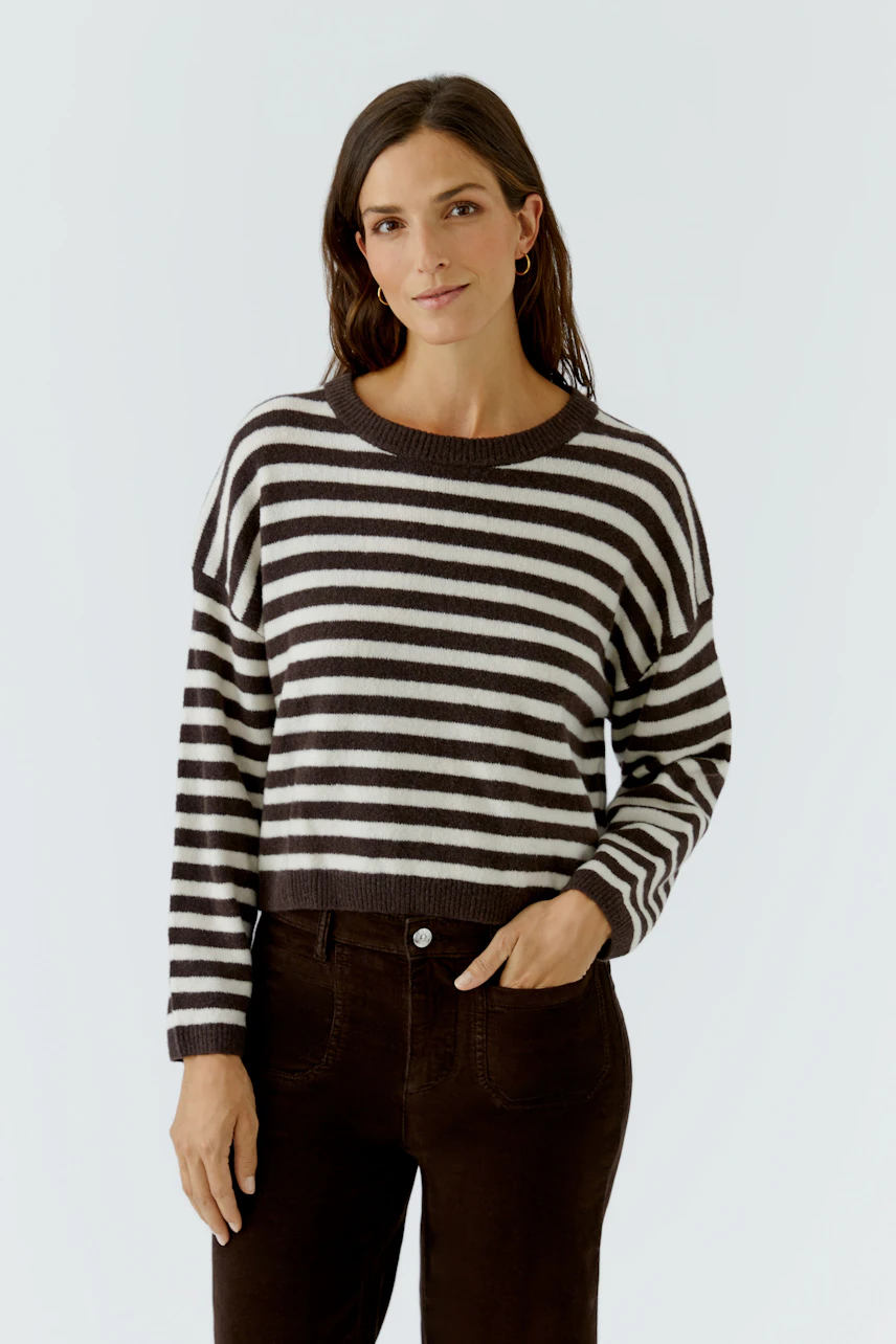Gestreifter Damen-Pullover: Frau im schwarz-weiß gestreiften Pullover, lässig und modern.