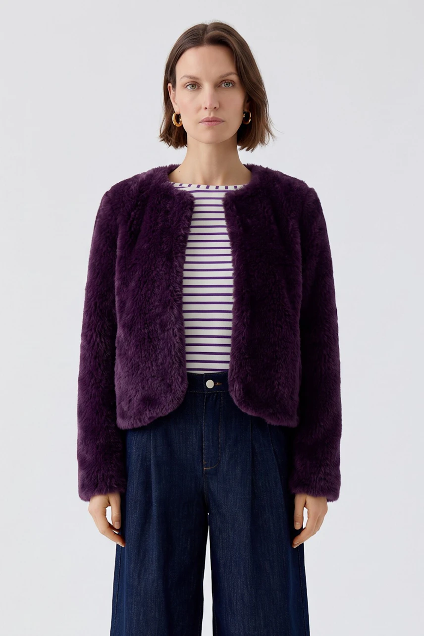 Woman in purple cardigan over striped top and wide-leg jeans, looking forward.