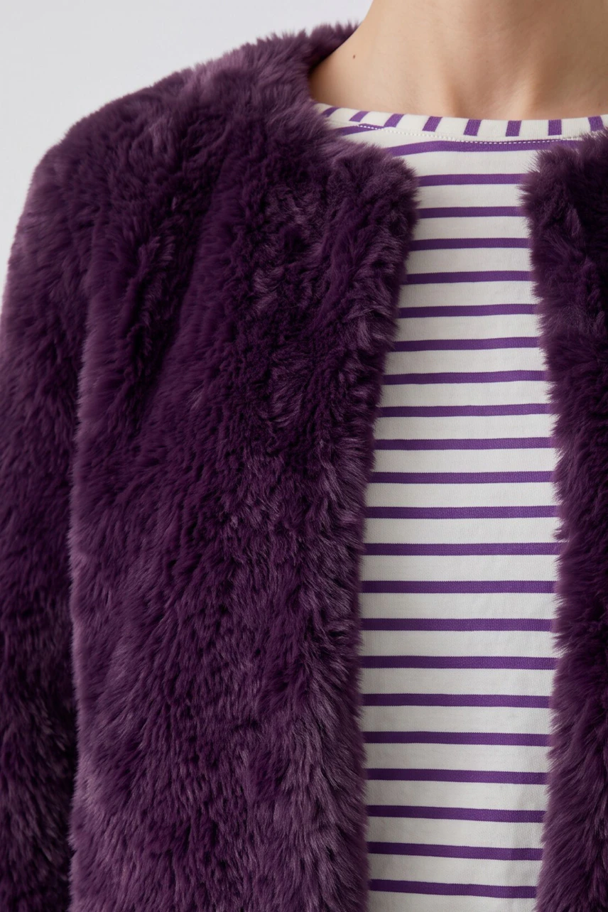 Woman in a fluffy purple cardigan over a striped shirt, showcasing cozy style.