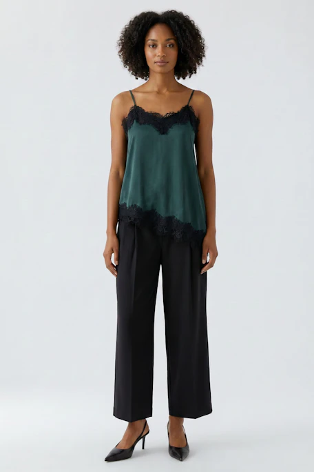 Damen-Top: Grünes Top mit schwarzer Spitze, asymmetrischer Saum. Ideal für lässige Outfits.