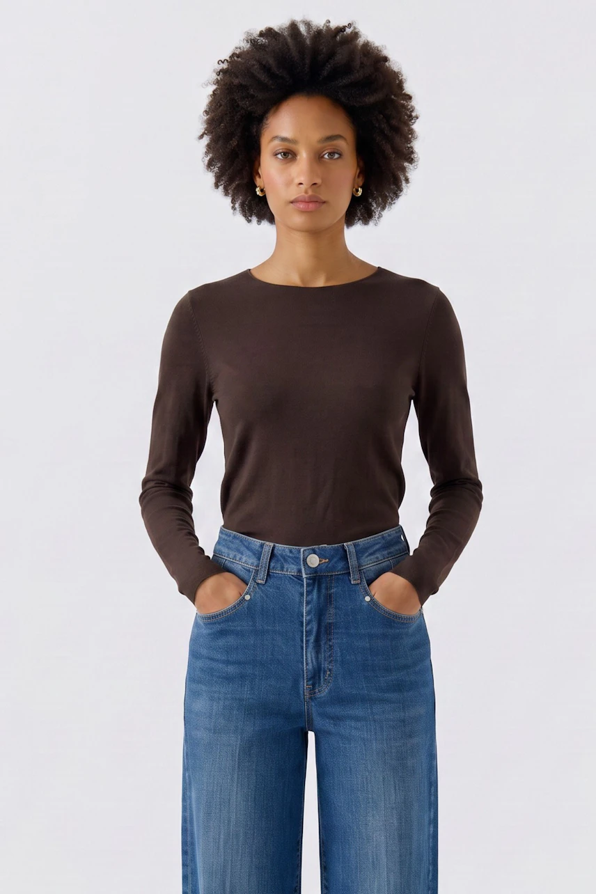 Frau im braunen Langarmshirt und blauer Jeans. Schlichtes Design, ideal für lässige Outfits.