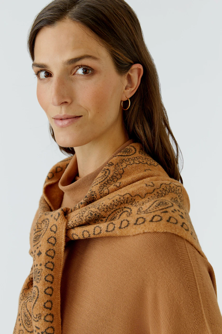 Frau mit braunem Schal: Dezenter Print, locker um die Schultern gelegt, ergänzt den lässigen Look.