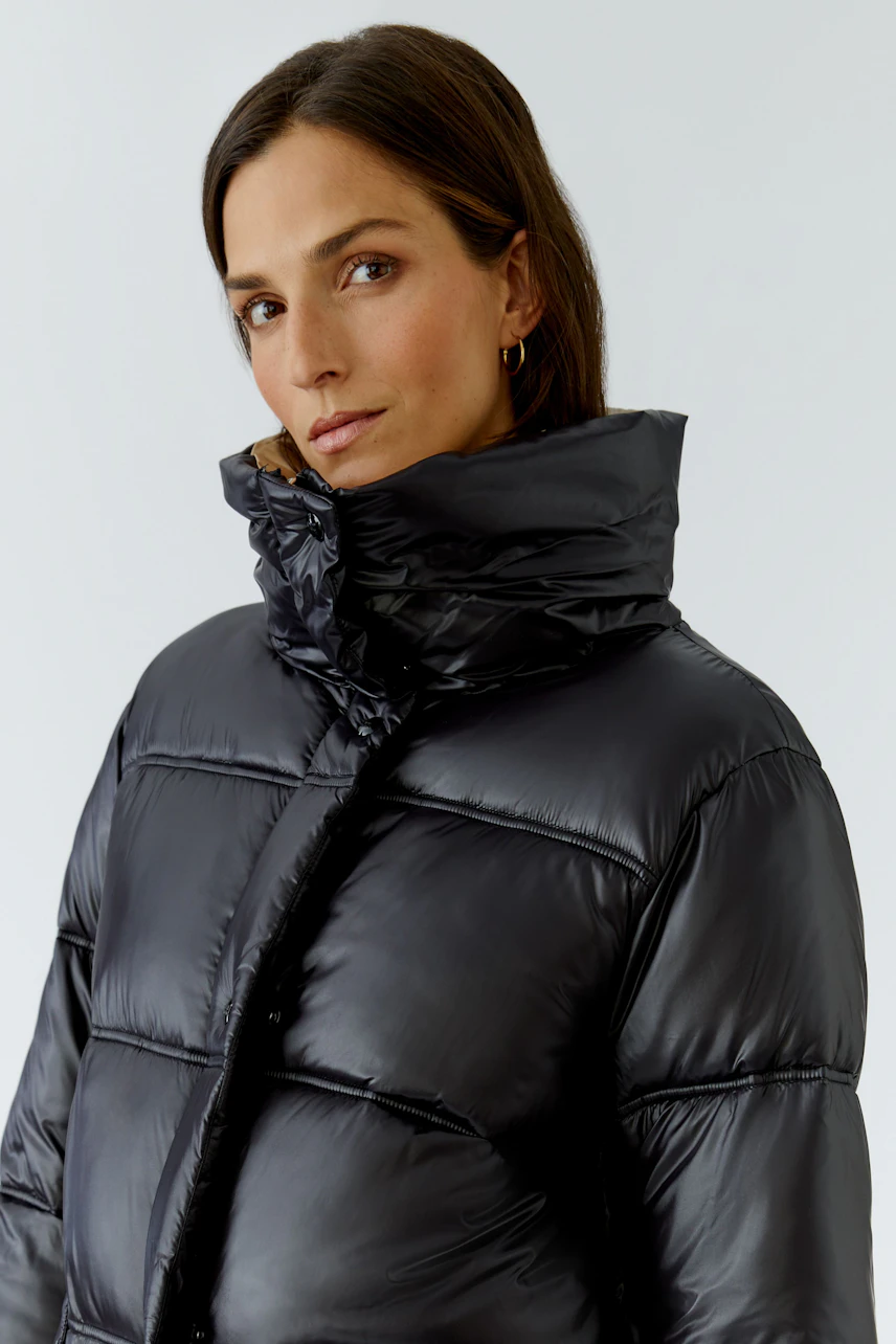 Frau in schwarzer Outdoorjacke: Steppjacke mit hohem Kragen, ideal für kalte Tage.
