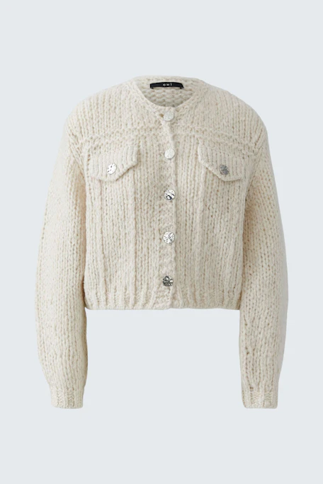 Cremefarbene Strickjacke: Weiche, grob gestrickte Jacke mit Knopfleiste und Brusttaschen.