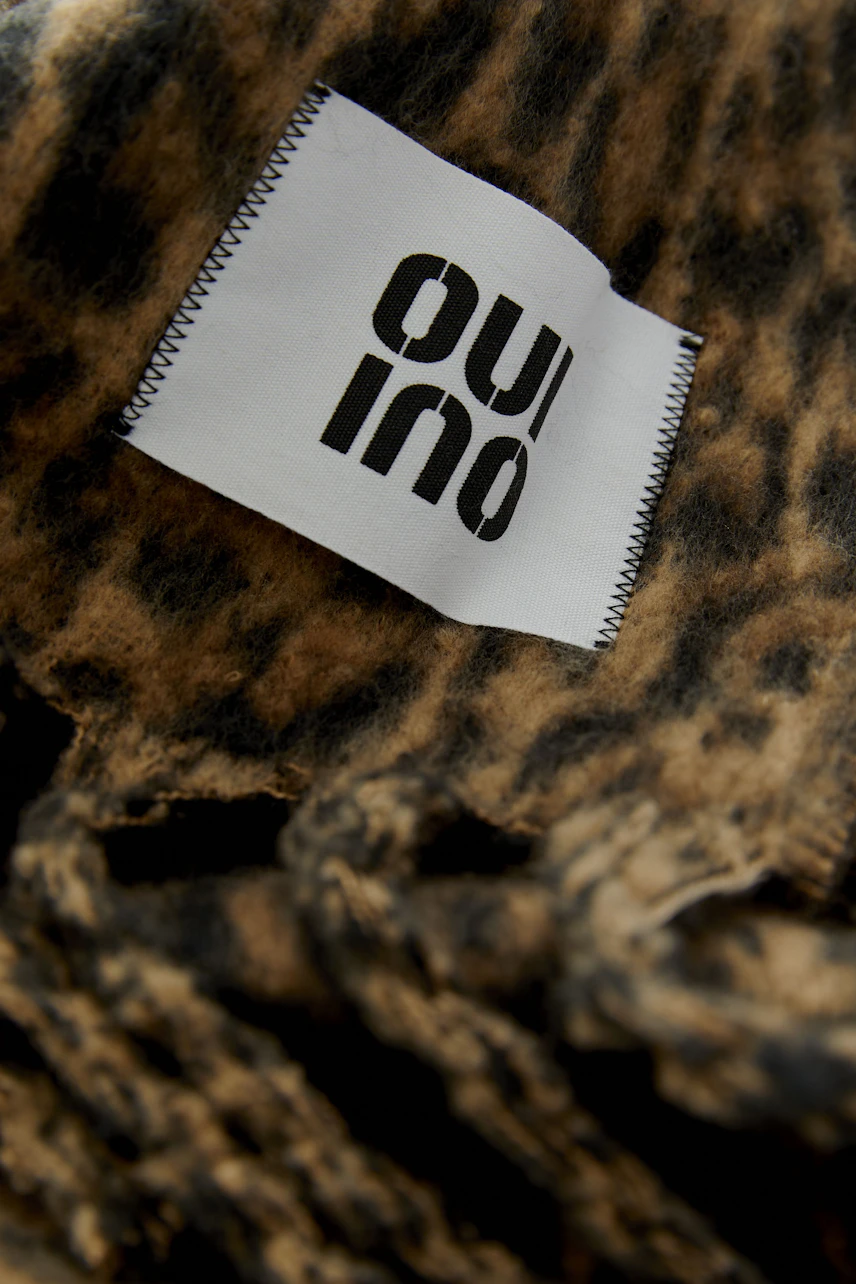 Leopard print scarf with fringes, perfect for adding a bold touch to any outfit.