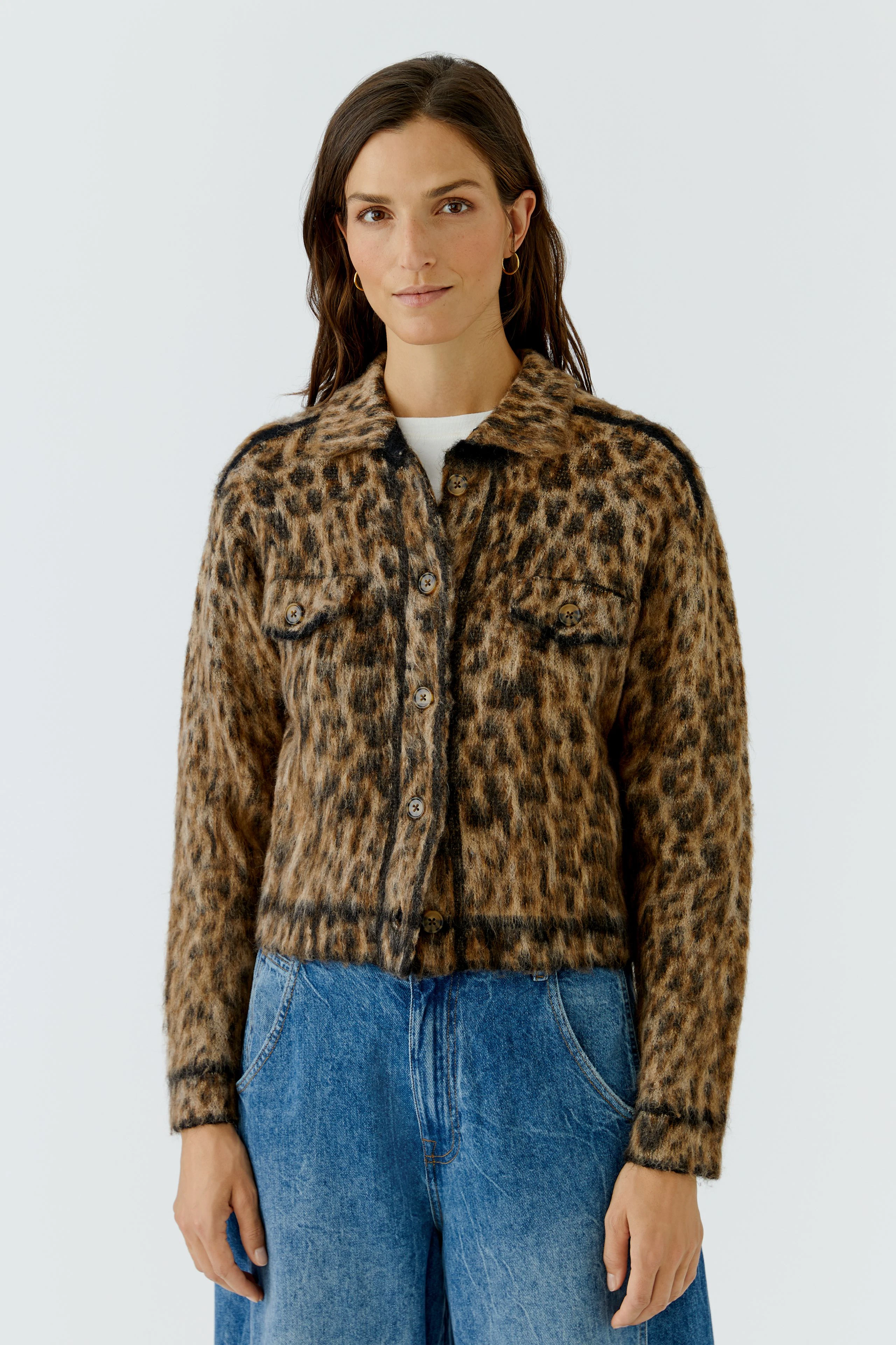 Leopard print cardigan: Woman in a cozy knit cardigan with blue jeans, exuding casual style.