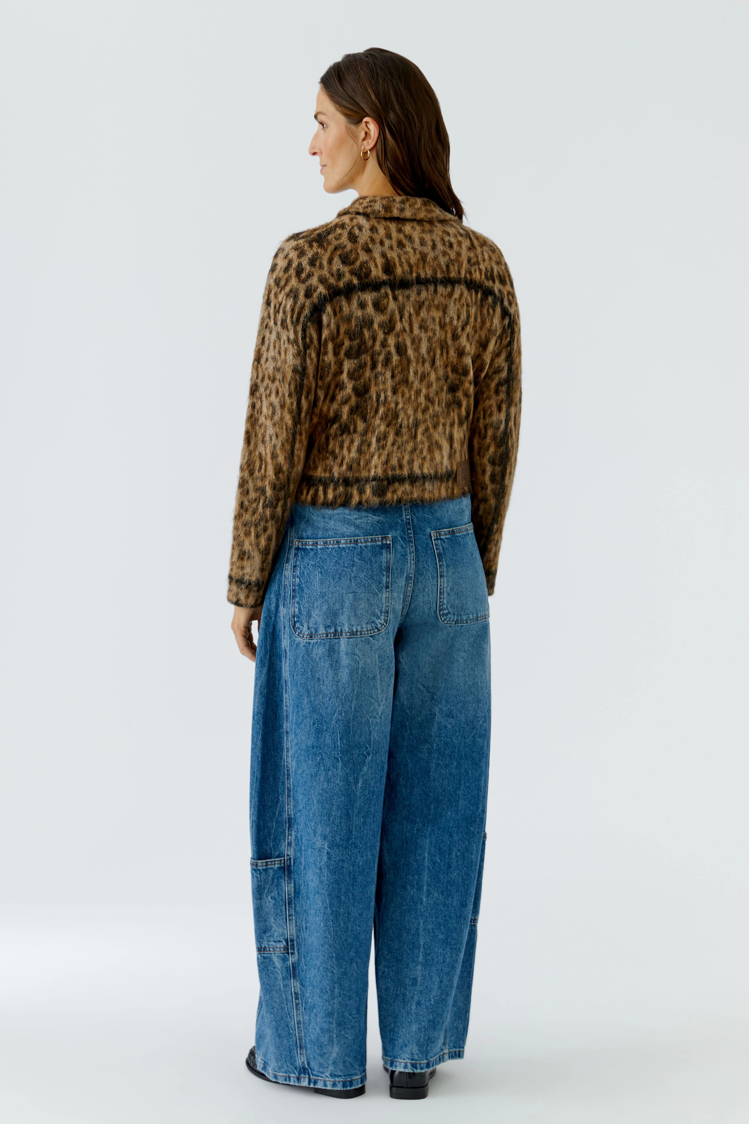 Leopard print cardigan: Woman in a stylish cardigan with wide-leg jeans, viewed from the back.