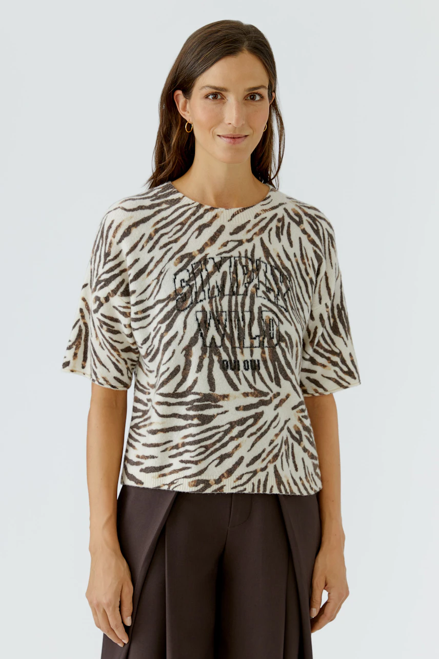 Damen-Pullover: Frau im gemusterten Pullover mit kurzen Ärmeln und lässigem Look.
