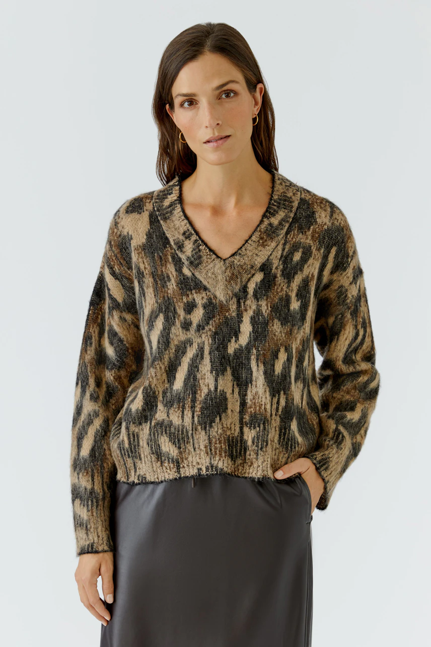 Damen-Pullover: Frau im gemusterten Pullover mit V-Ausschnitt und Rock, lässiger Look.