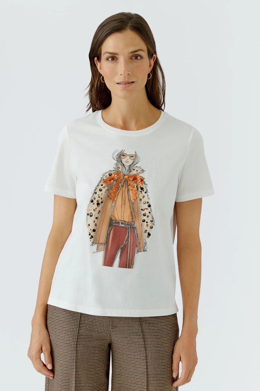 Casual women's T-shirt: Woman in white T-shirt with graphic print, paired with checkered pants.