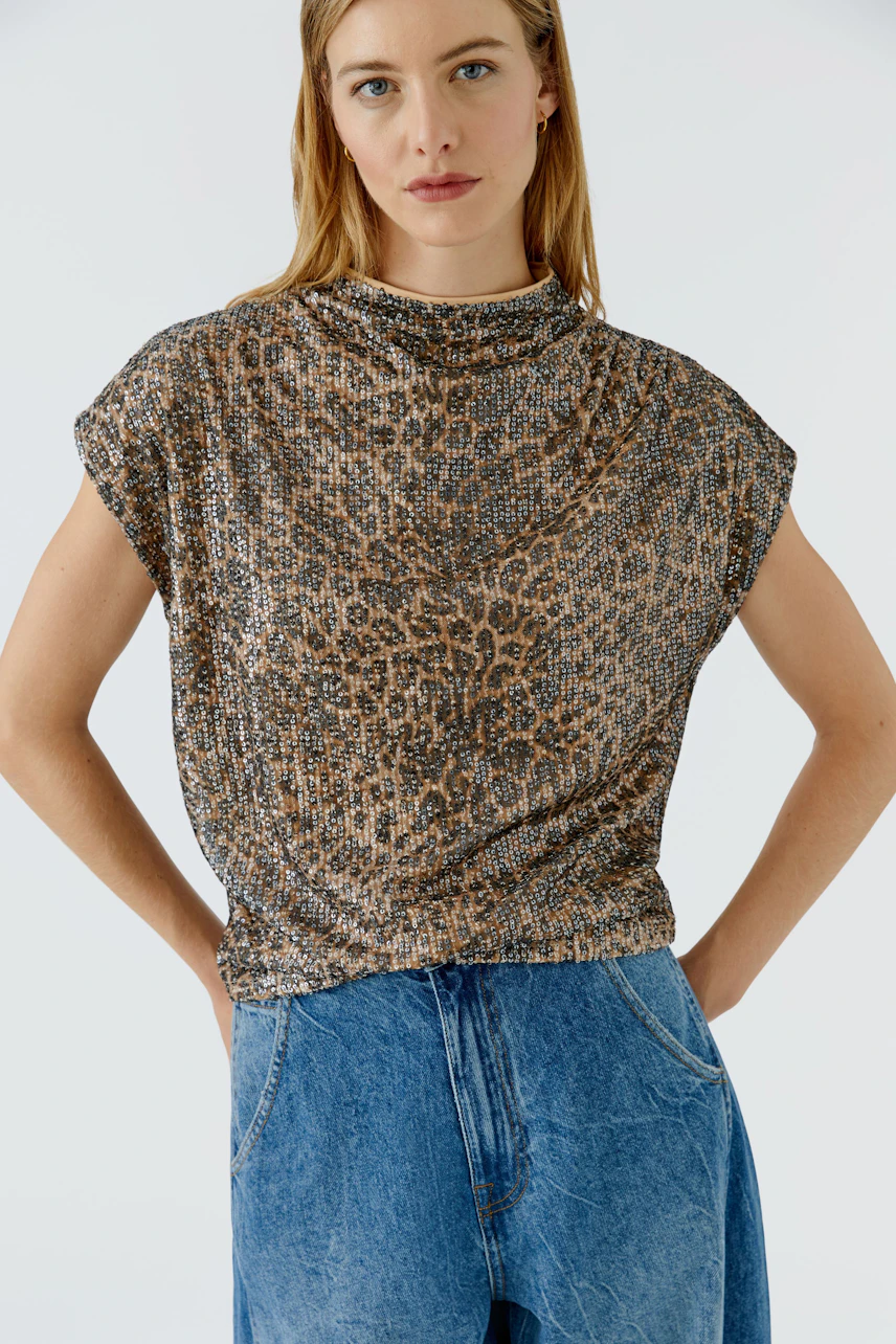 Blusenshirt: Frau im gemusterten Blusenshirt und blauer Jeans, lässiger Look.