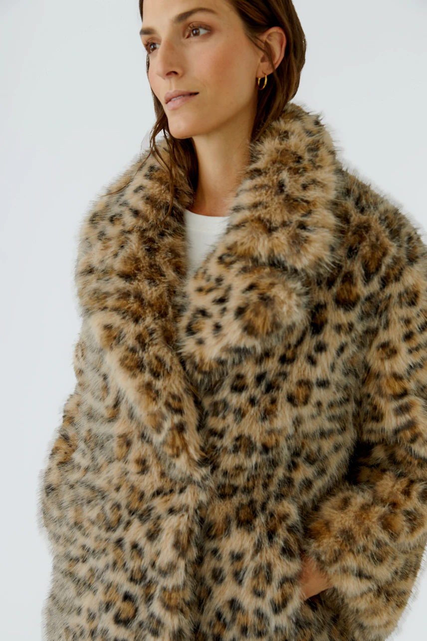 Frau in flauschiger Outdoorjacke mit Leopardenmuster, lässig und warm für kühle Tage.
