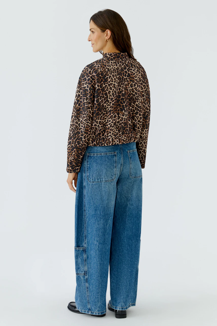 Damen-Jacke: Frau in lässiger Leopardenjacke und blauer Jeans von hinten.