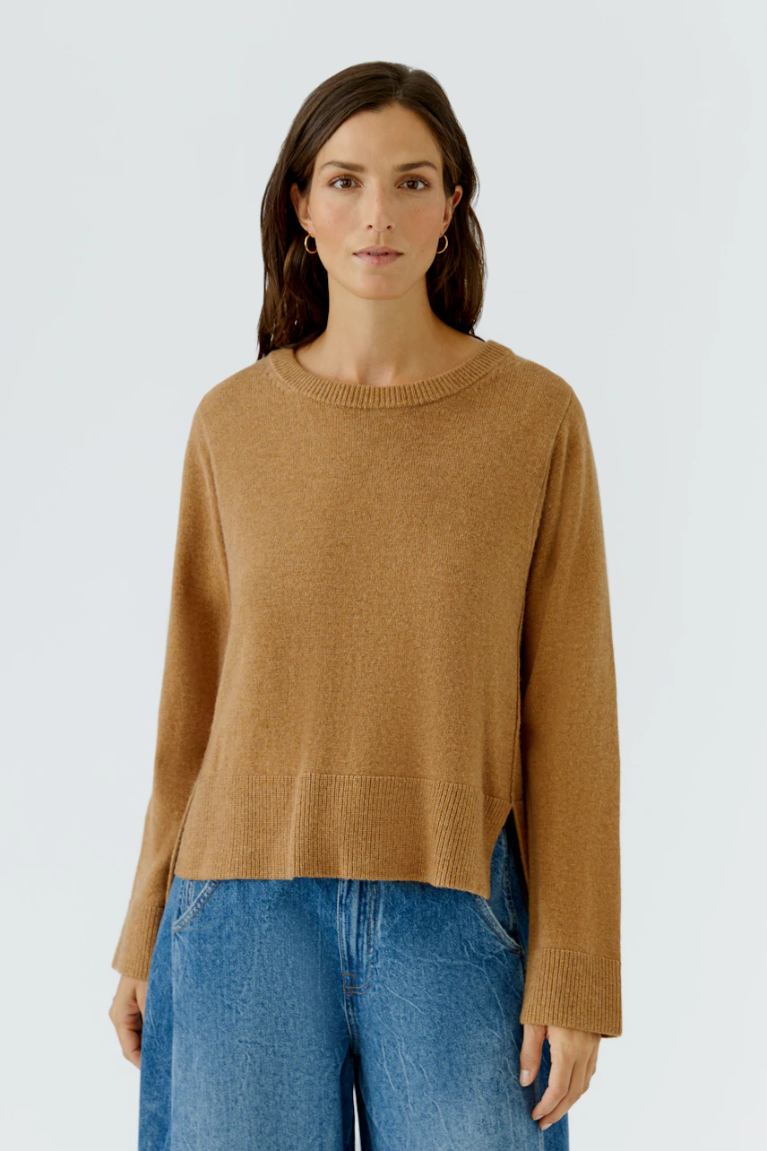 Lässiger Damen-Pullover: Frau im braunen Pullover und blauen Jeans, schlicht und bequem.