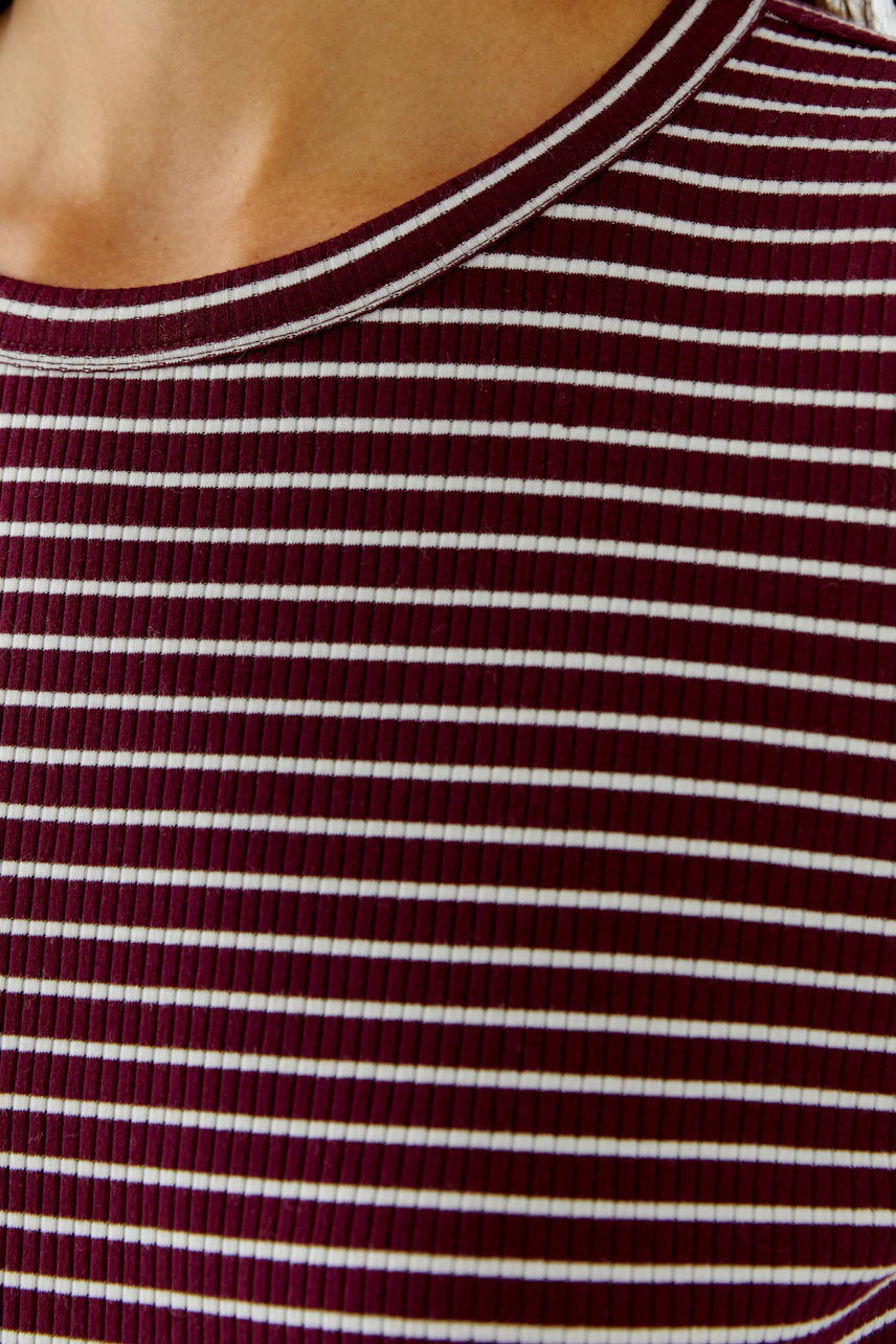 Gestreiftes Langarmshirt: Frau trägt ein weinrot-weiß gestreiftes Shirt mit Rundhalsausschnitt.