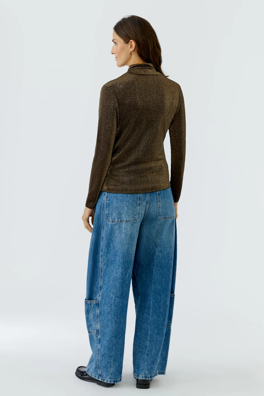 Casual long-sleeve shirt: Woman in brown shirt and wide blue jeans, viewed from the back.